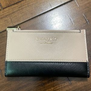 Kate Spade wallet. Cream and black on outside and pink inside.